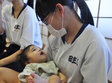 赤ちゃんふれあい体験で、生徒が赤ちゃんを抱いている様子