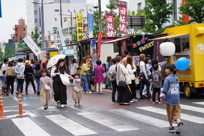 明治通りに並んだキッチンカーを巡る人々