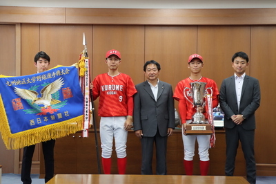 優勝旗とトロフィーを持つ野球部の選手らと市長