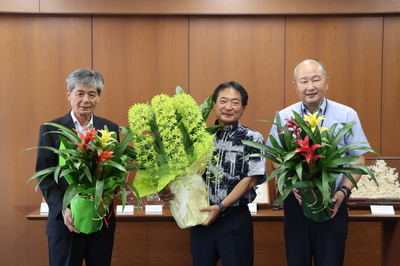 久留米花卉園芸農業共同組合の人と贈られた花鉢を持つ原口新五市長