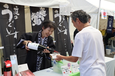 気になる酒をついでもらう来場者