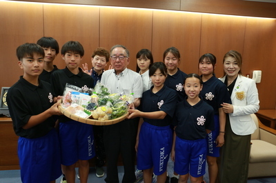 副市長から食材を受け取るジュニアアスリートたち