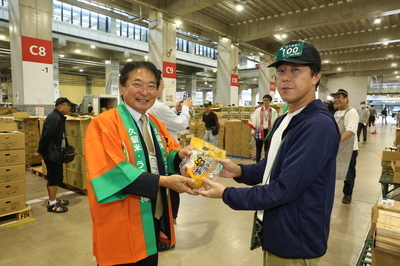 原口市長が柿とトマトを手渡す様子