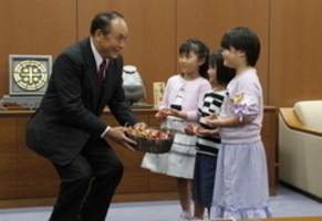 贈呈式で、子どもにチューリップの球根を寄贈しているときの写真です。
