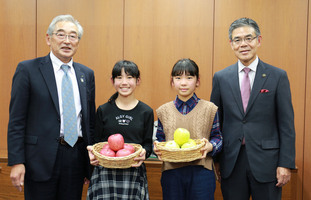 りんごの贈呈式にて、贈呈元と市長、子ども2人による写真です。