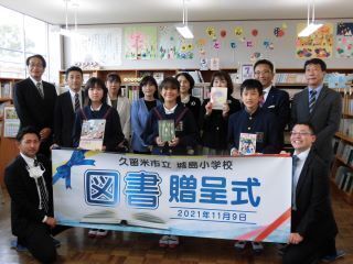 1枚目：創価学会からの贈呈セレモニーの集合写真です。