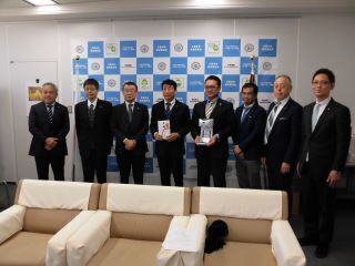 福岡県宅地建物取引業協会からの贈呈セレモニーの集合写真です。