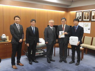 2枚目： 福岡酸素株式会社からの贈呈セレモニーの集合写真です。