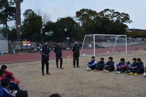 サッカー教室で熱心に講師の話を聞く子どもたちの写真