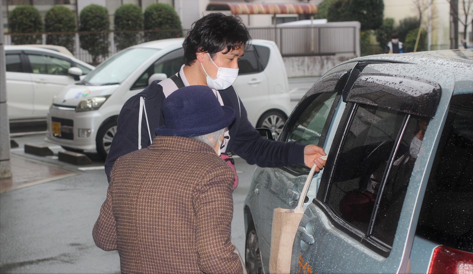 利用者を車に乗せる介護職員