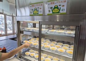 食堂でサラダをとる人
