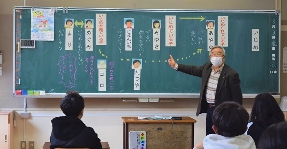西村さんが小学生に話をしている写真