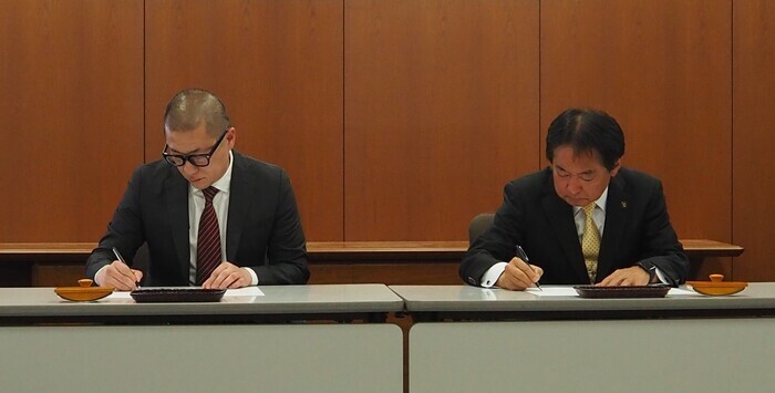 協定書に署名をしている画像