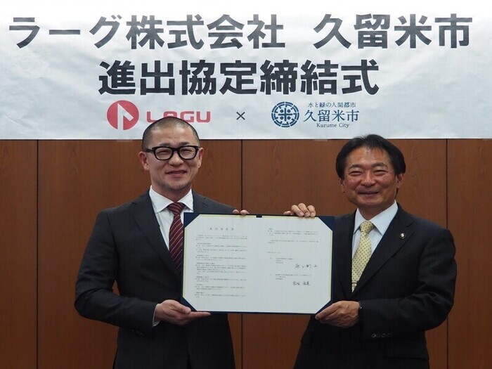 協定書を掲げる画像