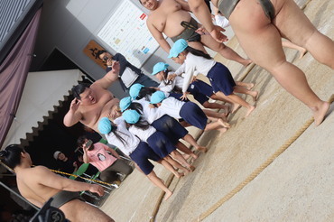 力士を押し出す園児たち